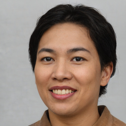 Joyful asian young-adult female with medium  brown hair and brown eyes