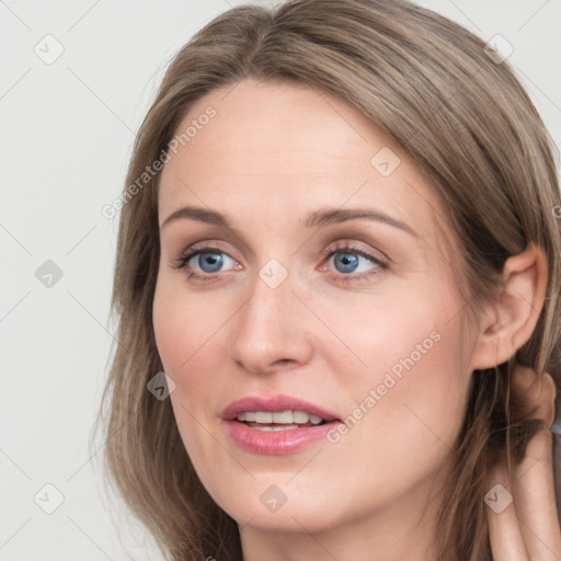 Joyful white young-adult female with long  brown hair and grey eyes