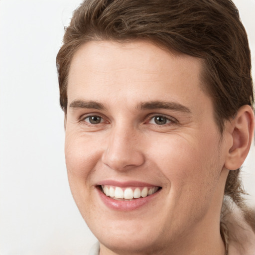 Joyful white young-adult male with long  brown hair and brown eyes