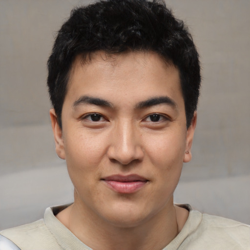 Joyful latino young-adult male with short  black hair and brown eyes