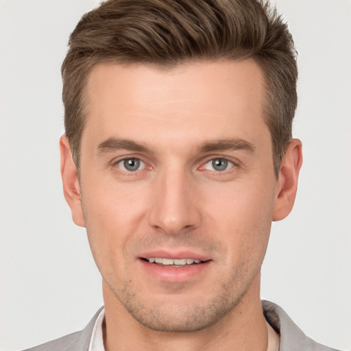 Joyful white young-adult male with short  brown hair and grey eyes