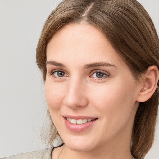 Joyful white young-adult female with medium  brown hair and grey eyes