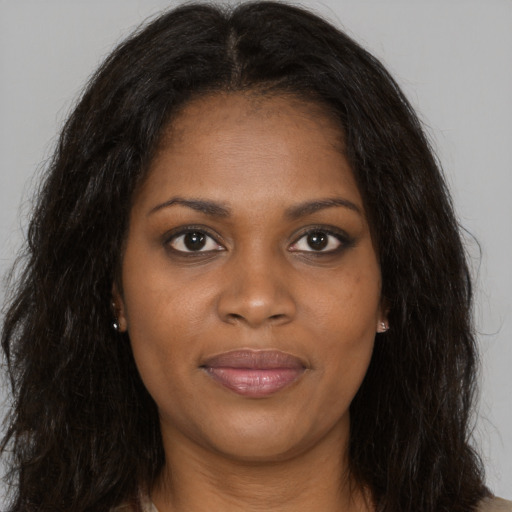 Joyful black young-adult female with long  brown hair and brown eyes