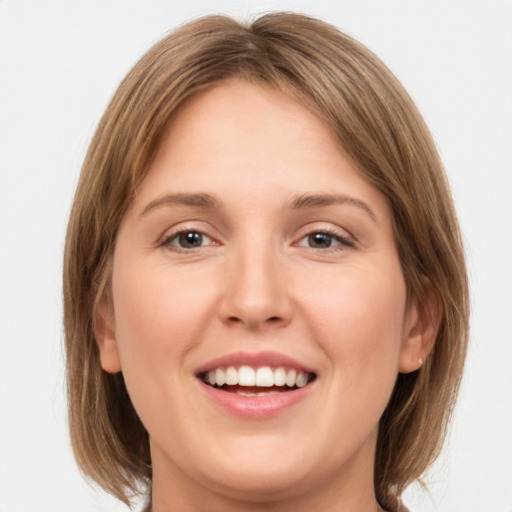 Joyful white young-adult female with medium  brown hair and green eyes