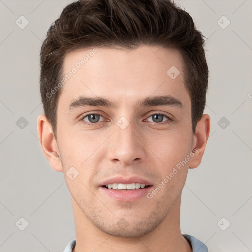 Joyful white young-adult male with short  brown hair and grey eyes