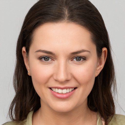 Joyful white young-adult female with long  brown hair and brown eyes