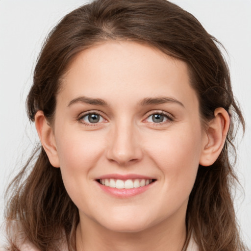 Joyful white young-adult female with long  brown hair and grey eyes