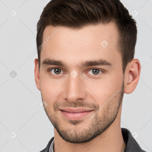 Joyful white young-adult male with short  brown hair and brown eyes