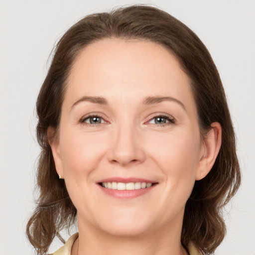 Joyful white young-adult female with medium  brown hair and grey eyes