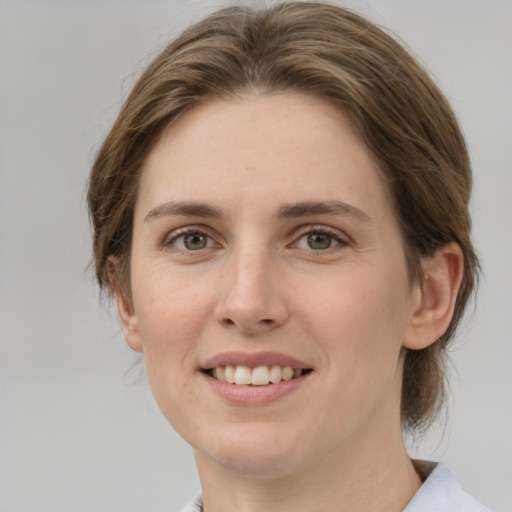 Joyful white young-adult female with medium  brown hair and grey eyes