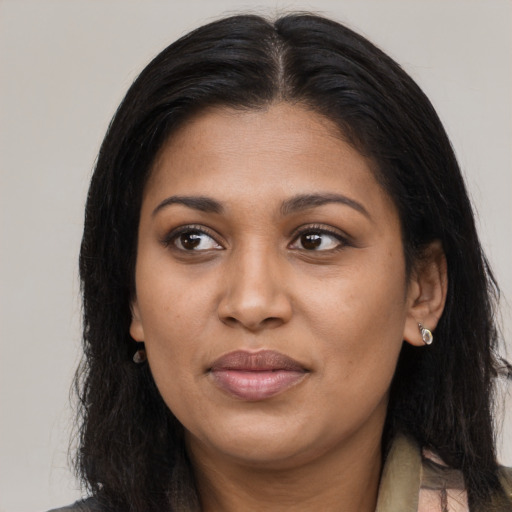 Joyful black young-adult female with long  brown hair and brown eyes