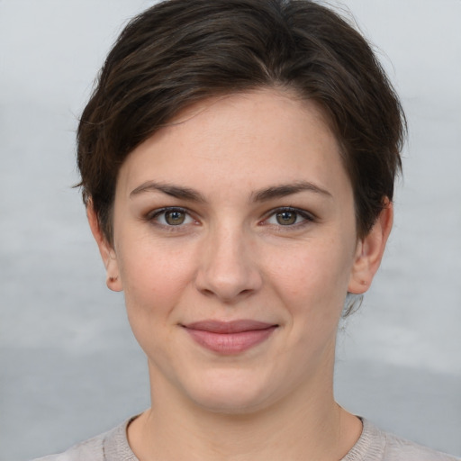 Joyful white young-adult female with short  brown hair and grey eyes