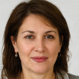 Joyful white adult female with medium  brown hair and grey eyes