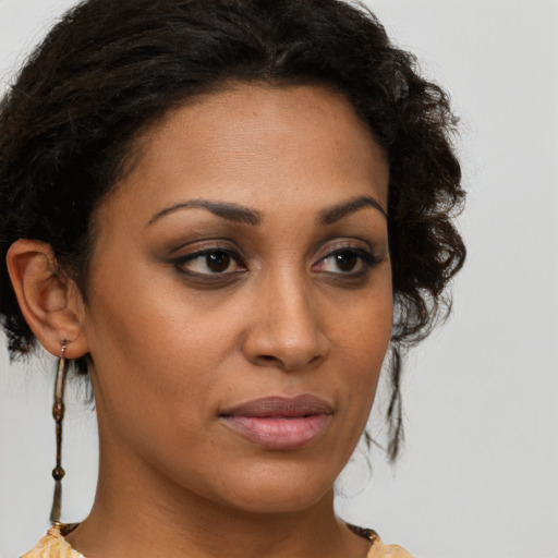 Joyful black young-adult female with medium  brown hair and brown eyes