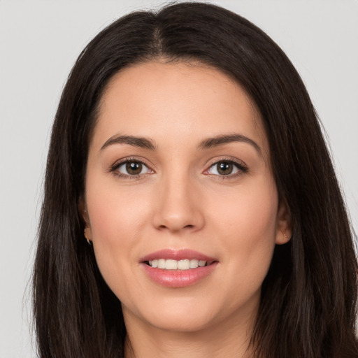 Joyful white young-adult female with long  brown hair and brown eyes