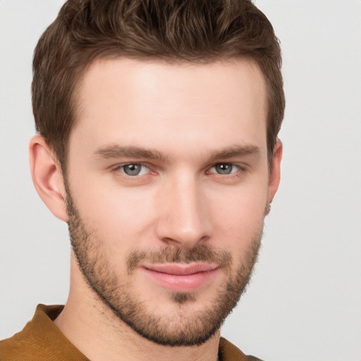 Joyful white young-adult male with short  brown hair and grey eyes