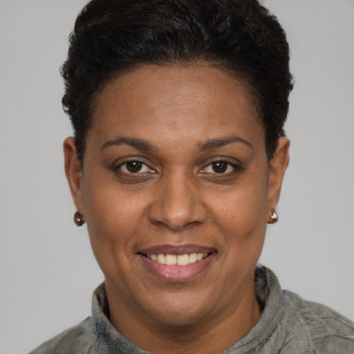 Joyful black adult female with short  black hair and brown eyes