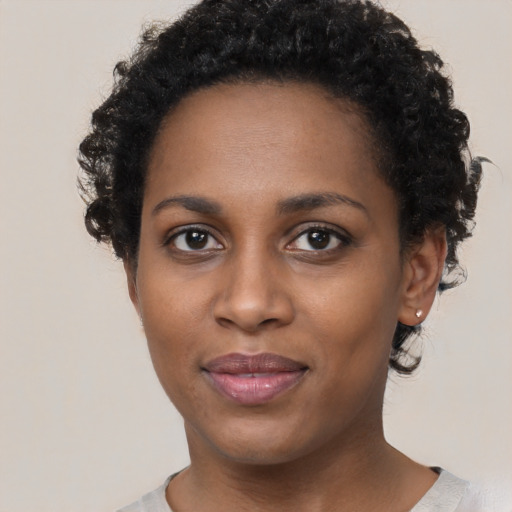 Joyful black young-adult female with short  black hair and brown eyes