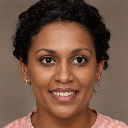 Joyful black young-adult female with short  brown hair and brown eyes