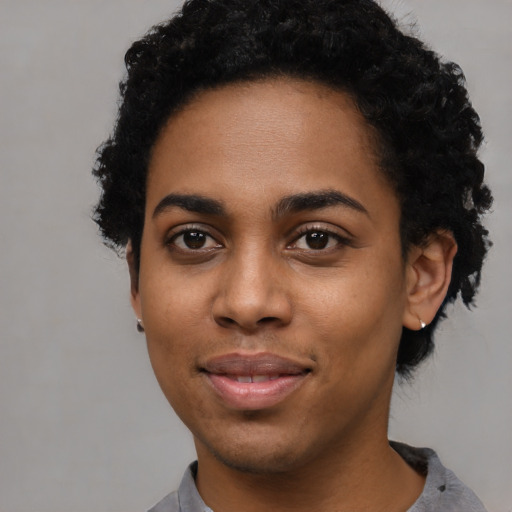 Joyful black young-adult female with short  black hair and brown eyes
