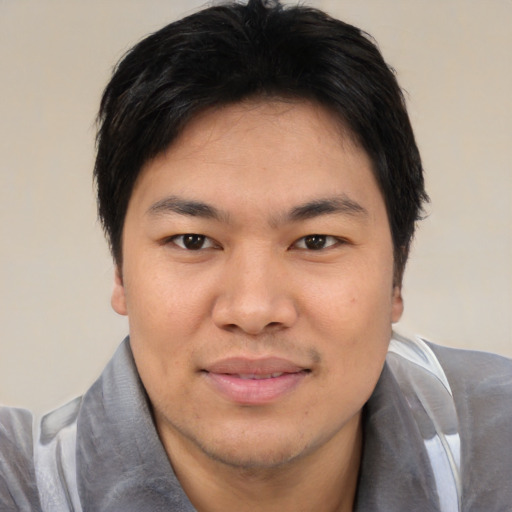 Joyful asian young-adult male with short  black hair and brown eyes