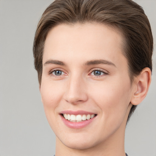 Joyful white young-adult female with short  brown hair and grey eyes