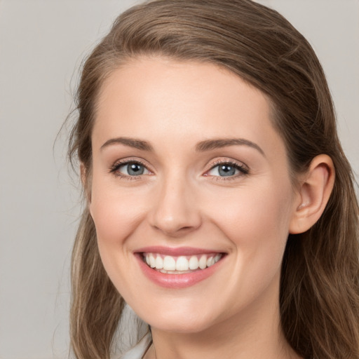 Joyful white young-adult female with long  brown hair and grey eyes