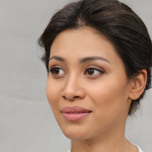 Joyful latino young-adult female with medium  brown hair and brown eyes