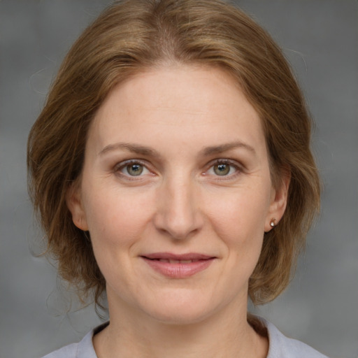 Joyful white adult female with medium  brown hair and grey eyes