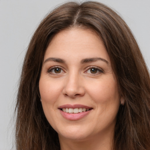 Joyful white young-adult female with long  brown hair and brown eyes