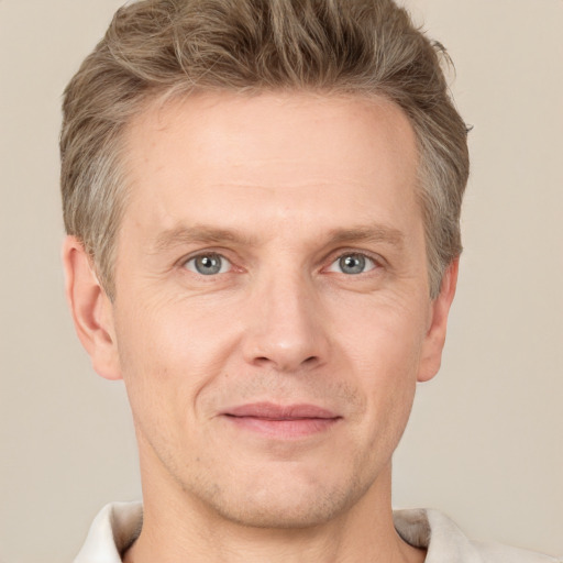 Joyful white adult male with short  brown hair and grey eyes