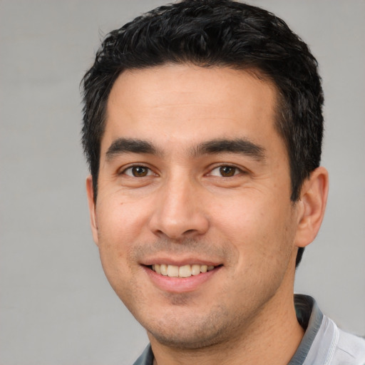 Joyful white young-adult male with short  black hair and brown eyes