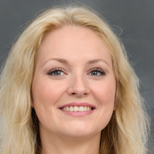 Joyful white young-adult female with long  brown hair and blue eyes