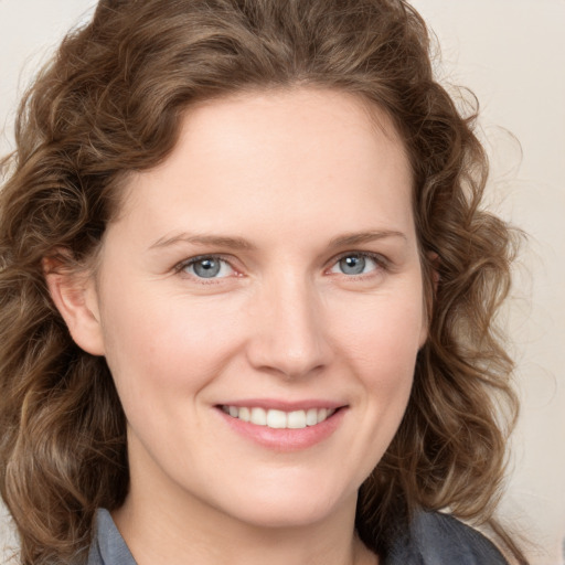 Joyful white young-adult female with medium  brown hair and blue eyes