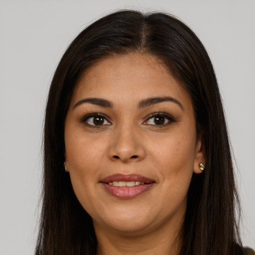 Joyful latino young-adult female with long  brown hair and brown eyes