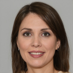 Joyful white young-adult female with medium  brown hair and green eyes