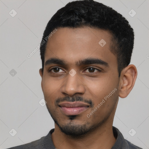 Joyful black young-adult male with short  black hair and brown eyes