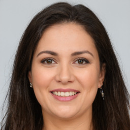 Joyful white young-adult female with long  brown hair and brown eyes