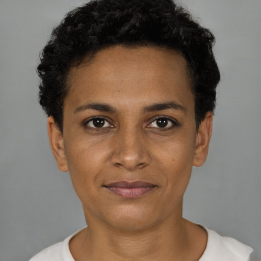 Joyful black young-adult female with short  black hair and brown eyes