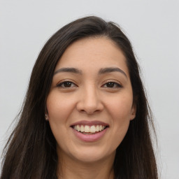 Joyful latino young-adult female with long  brown hair and brown eyes