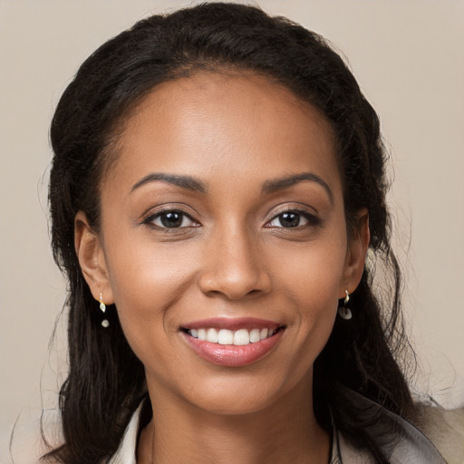 Joyful black young-adult female with long  brown hair and brown eyes