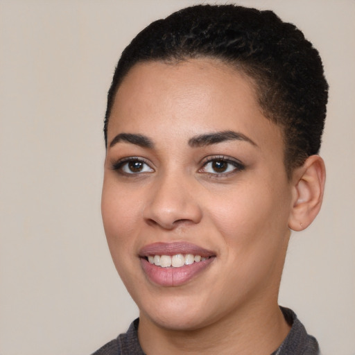 Joyful black young-adult female with short  black hair and brown eyes