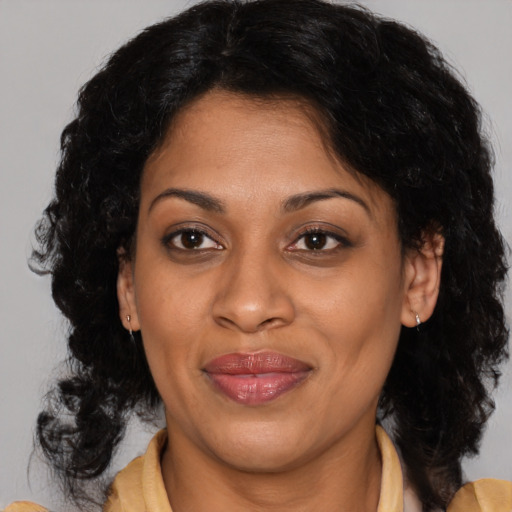 Joyful latino adult female with medium  brown hair and brown eyes