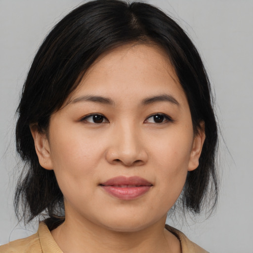 Joyful asian young-adult female with medium  black hair and brown eyes