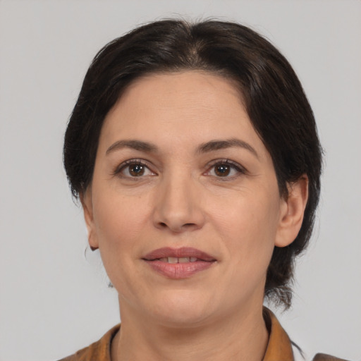 Joyful white adult female with medium  brown hair and brown eyes