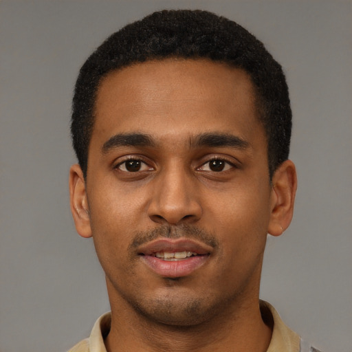 Joyful black young-adult male with short  brown hair and brown eyes