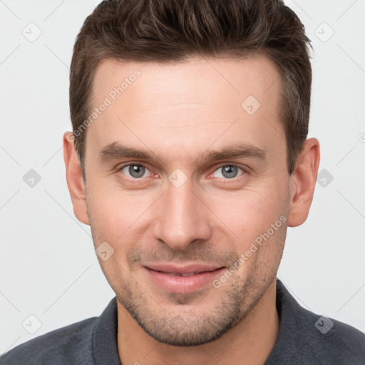 Joyful white young-adult male with short  brown hair and grey eyes