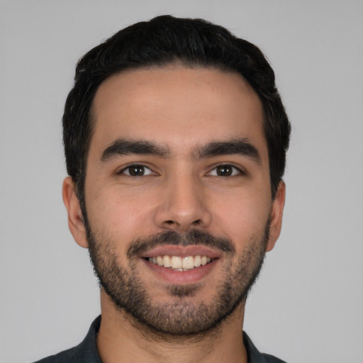 Joyful white young-adult male with short  black hair and brown eyes