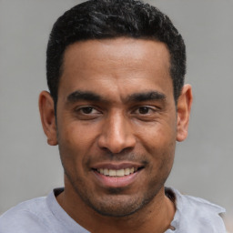 Joyful latino young-adult male with short  black hair and brown eyes
