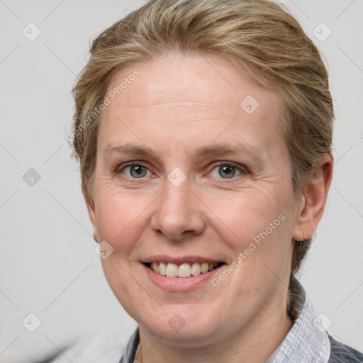 Joyful white adult female with medium  brown hair and blue eyes